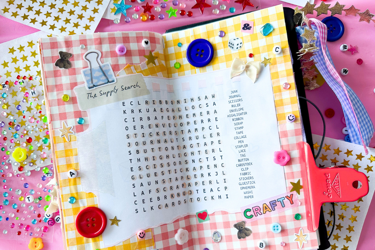 Open journal with trinkets and other stationery surrounding it